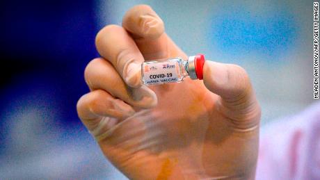 A laboratory technician holding a dose of a COVID-19 novel coronavirus vaccine candidate ready for trial.