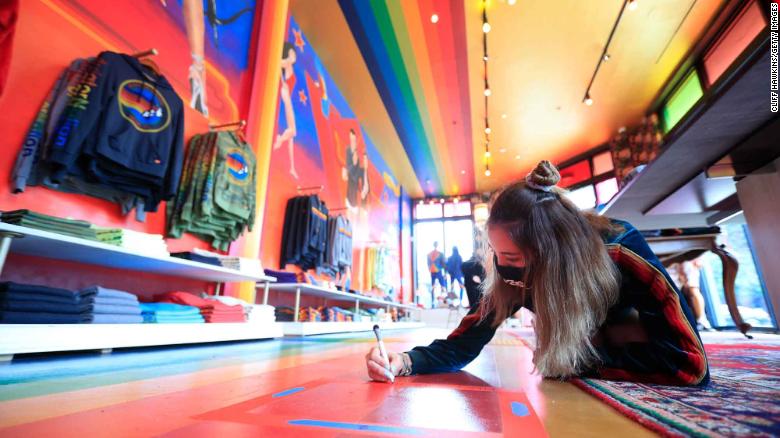 MIAMI, FLORIDA - MAY 20:  Dilhum Arango marks social distancing spots on the floor inside of the Aviator Nation clothing store on May 20, 2020 in the Wynwood neighborhood of Miami, Florida. The city of Miami is allowing non-essential &quot;retail stores, personal grooming establishments, offices and museums&quot; to reopen after COVD-19 pandemic staring today. (Photo by Cliff Hawkins/Getty Images)