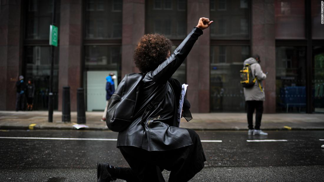 A woman kneels during a rally in London.