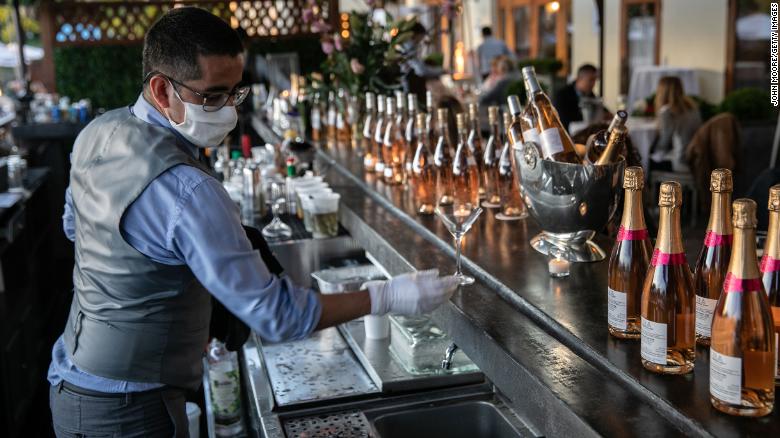 GREENWICH, CONNECTICUT - MAY 20: A bartender serves drinks at L&#39;escale restaurant on May 20, 2020 in Greenwich, Connecticut. After two months of closures due to the Coronavirus pandemic, Connecticut partially reopened businesses on May 20, one of the last states to do so. Restaurants can now serve patrons at outdoor seating at socially distanced tables. (Photo by John Moore/Getty Images)