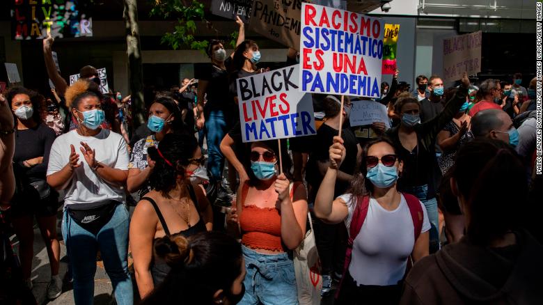 In Madrid, a protester warns that "Systemic racism is a pandemic." 