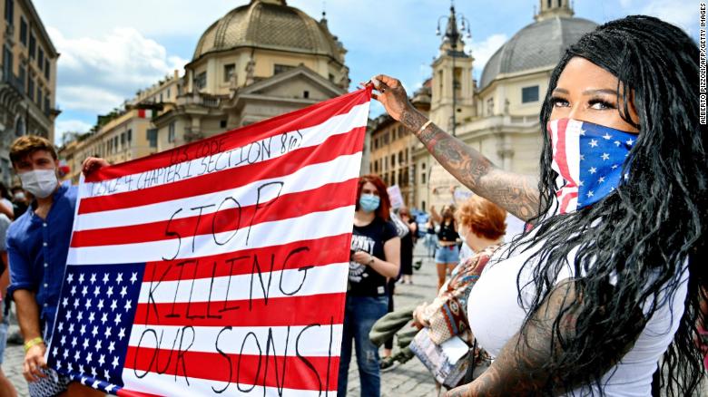 Protesters hold an upside-down US flag in Rome.