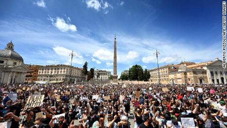Los manifestantes se arrodillan sosteniendo pancartas en Roma.