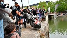 Protesters throw a statue of slave trader Edward Colston into Bristol harbour, during a Black Lives Matter protest rally, in Bristol, England, Sunday June 7, 2020, in response to the recent killing of George Floyd by police officers in Minneapolis, USA, that has led to protests in many countries and across the US. (Ben Birchall/PA via AP)