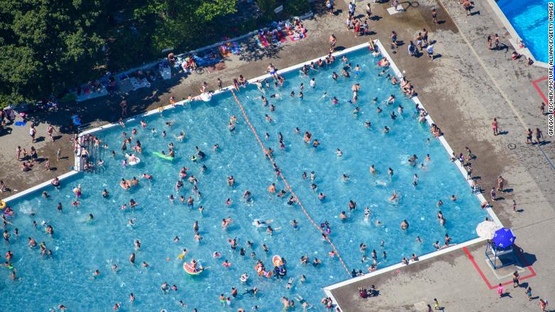 Children and adults bathe and sunbathe in the Mariendorf summer pool in Berlin, Germany, in June 2019.