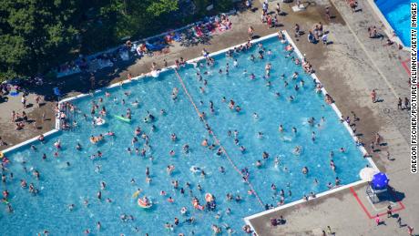 Des enfants et des adultes se baignent et prennent le soleil dans la piscine d'été de Mariendorf à Berlin, en Allemagne, en juin 2019.