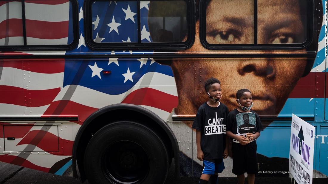 Children pose in front of a bus depicting abolitionist Harriet Tubman.