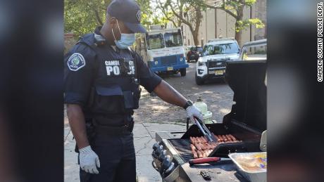 A Camden County officer grills hot dogs for one of the department's pop-up neighborhood parties. 
