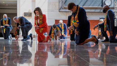 House Speaker Nancy Pelosi, center, and other members of Congress, kneel and observe a moment of silence at the Capitol&#39;s Emancipation Hall on Monday.