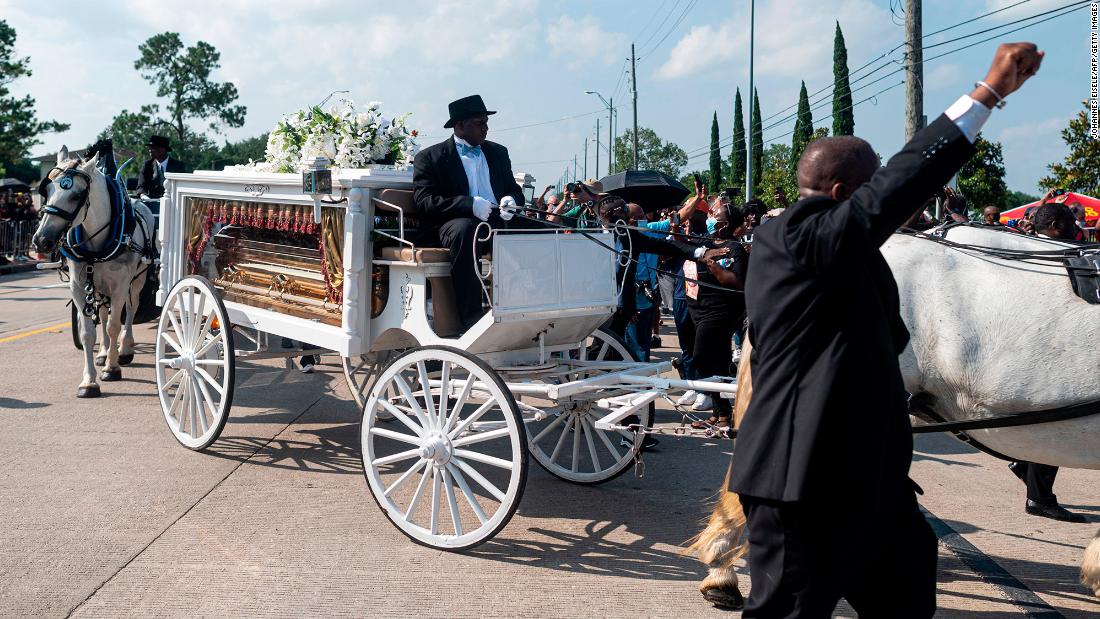 A horse-drawn carriage carries Floyd&#39;s casket to Houston Memorial Gardens.