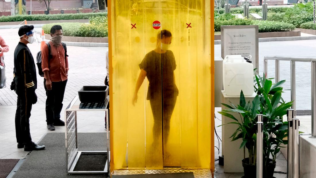 A woman is sprayed with disinfectant before entering a shopping mall in Jakarta, Indonesia, on June 9, 2020.