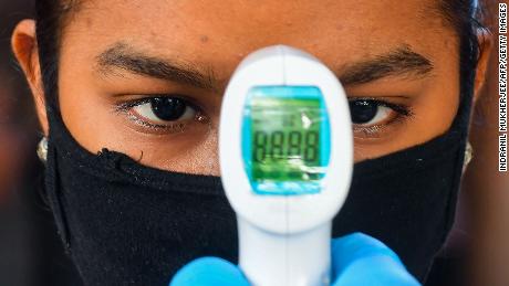 A Mumbai resident gets her temperature tested at a screening center inside a slum.