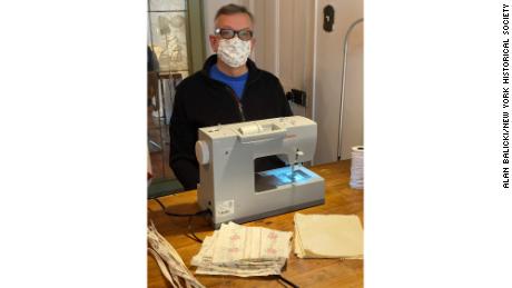 A man uses a sewing machine to create homemade face masks during lockdown in New York City