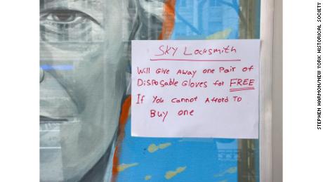  A sign appears in a locksmith&#39;s window offering a free pair of disposable gloves to anyone who can&#39;t afford it in New York City