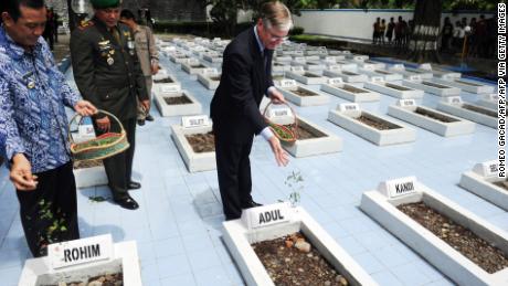 Former Dutch Ambassador to Indonesia Tjeerd de Zwaan, center, leaves flowers at the graves of victims of a 1947 massacre, in Rawagede, Indonesia, on December 9, 2011, when the Netherlands made a formal apology. 