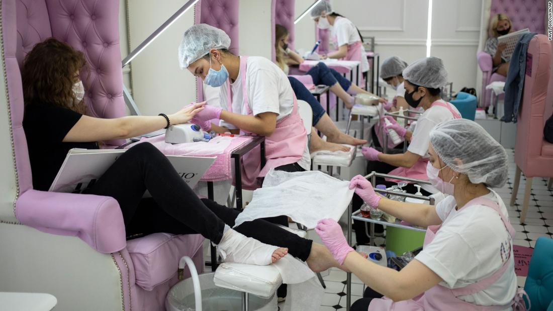 Nail technicians perform manicures and pedicures at a nail bar in Moscow on June 9. The Russian capital ended a tight lockdown that had been in place since late March.