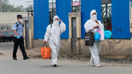 Beijing health authority workers inspect the city&#39;s vegetable market after staff there tested positive for coronavirus.