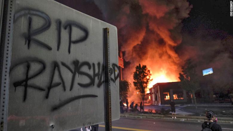 A Wendy's restaurant, background, burns Saturday in Atlanta. 