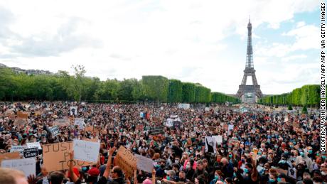 A protester holds a banner on Champ de Mars, in Paris on June 6, 2020, as part of  Black Lives Matter protests in the city.