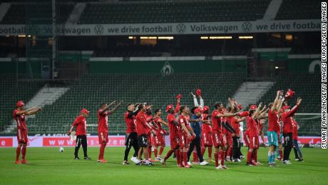 Bayern Munich players celebrate their eighth straight title inside the empty Weserstadion.