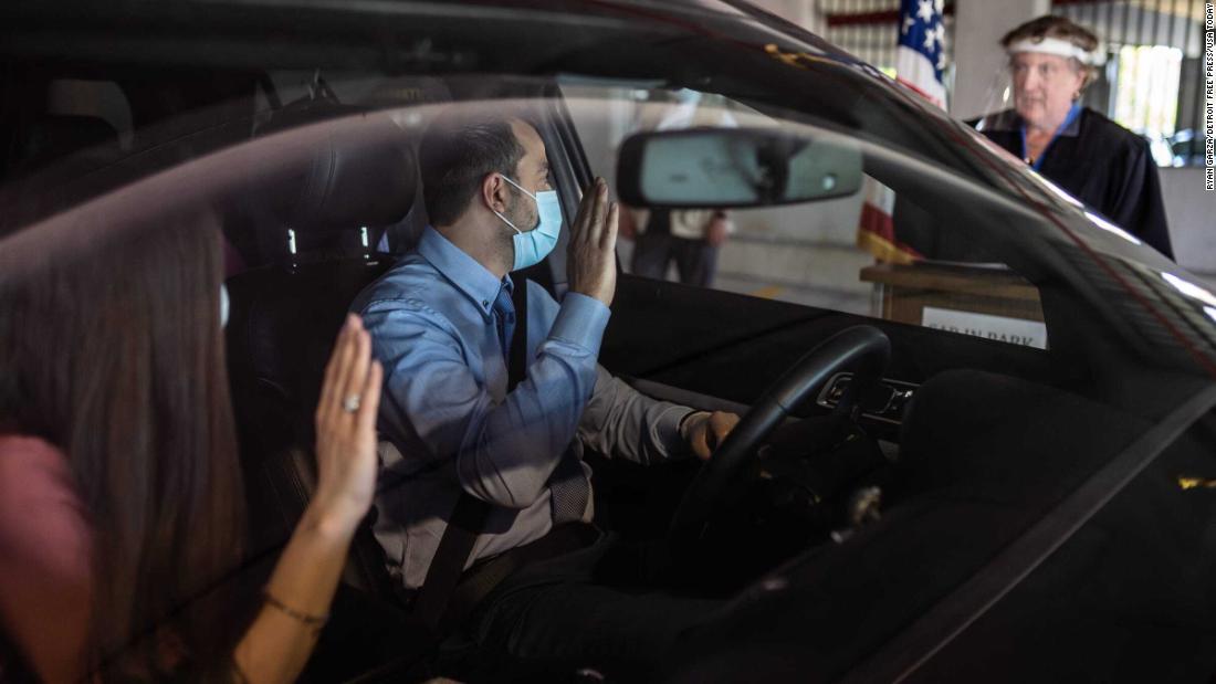 Charbel Abdo Habib and his wife, Rana El-hachem, raise their hands as Federal Magistrate Judge Patricia Morris swears them in during &lt;a href=&quot;https://www.usatoday.com/story/news/nation/2020/06/18/immigrants-becoming-citizens-via-drive-thru-ceremonies/3213245001/&quot; target=&quot;_blank&quot;&gt;a drive-thru naturalization ceremony&lt;/a&gt; in Detroit on June 17.