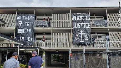 Refugees and asylum seekers hang signs made from bin bags over the balconies at the hotel in Kangaroo Point, Brisbane.