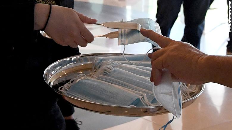 Tongs are used to give surgical masks to guests entering the Westgate Las Vegas Resort & Casino on June 18, 2020 in Las Vegas, Nevada.