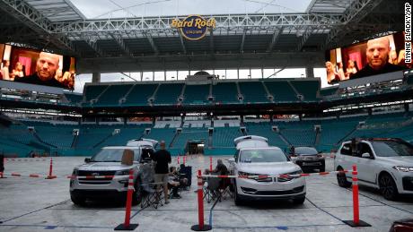 People watch a movie outside of their vehicles on the field at Hard Rock Stadium in Miami.