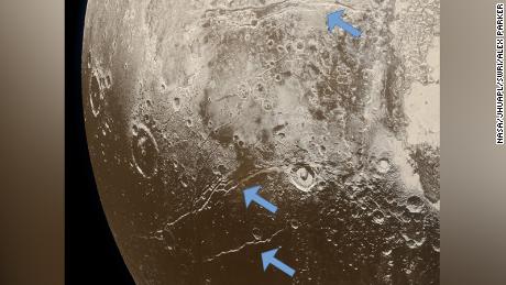 Extensional faults (indicated by arrows) on the surface of Pluto reveal expansion of the dwarf planet&#39;s icy crust. This was likely caused by the slow freezing of an ocean beneath the crust.