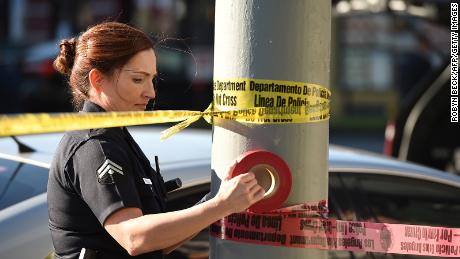 A female police officer uses police tape to cordon off an area outside a restaurant in Hollywood, California, in January 2017.