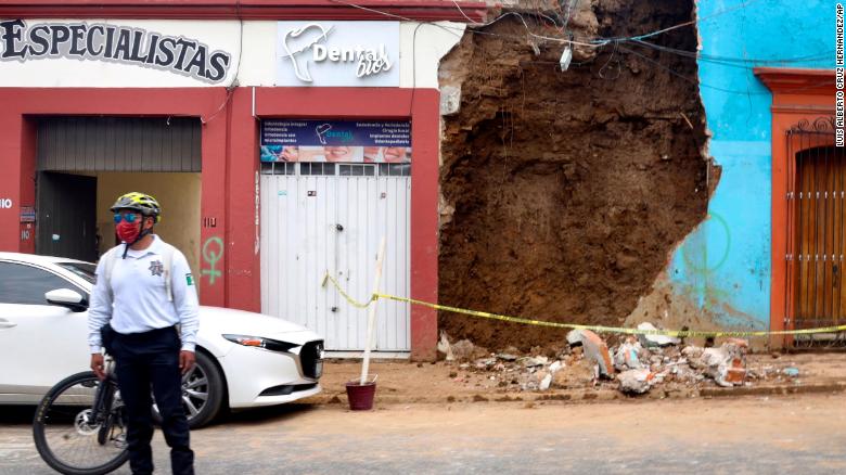 A policeman stands in front of a partially collapsed building after an earthquake in Oaxaca, Mexico.