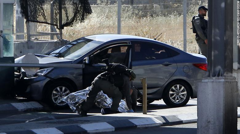 Israeli security forces cover the body of Palestinian Ahmad Erekat, who was shot dead at a checkpoint near Abu Dis in the West Bank.