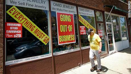 A man walks past a retail store that is going out of business due to the coronavirus pandemic in Winnetka, Ill., Tuesday, June 23, 2020. Illinois Gov. J.B Pritzker announced a package of state grant programs that will help support communities and businesses impacted by the COVID-19 pandemic and unrest in the area. (AP Photo/Nam Y. Huh)