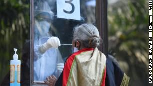 A medic collects a swab from a woman to test for Covid-19 on June 18 in New Delhi, India.   