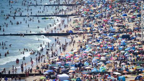 BOURNEMOUTH, ENGLAND - JUNE 25: Visitors crowd together as they enjoy the hot weather on the beach on June 25, 2020 in Bournemouth, United Kingdom. The UK is experiencing a summer heatwave, with temperatures in many parts of the country expected to rise above 30C and weather warnings in place for thunderstorms at the end of the week. (Photo by Finnbarr Webster/Getty Images)