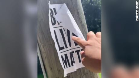 A screengrab from a video in which a far-right group member rips a Black Lives Matter poster from a tree.