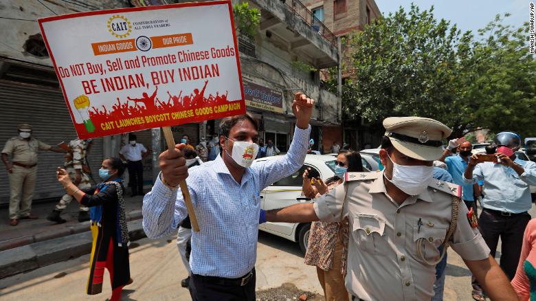Police detaining an Indian trader who was burning Chinese products during a protest in New Delhi on Monday.