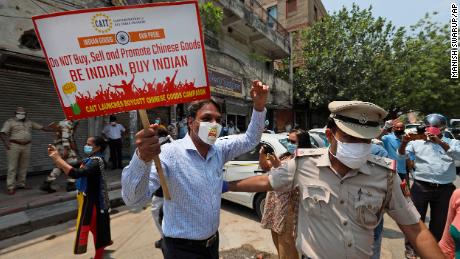 Police detaining an Indian trader who was burning Chinese products during a protest in New Delhi on Monday.