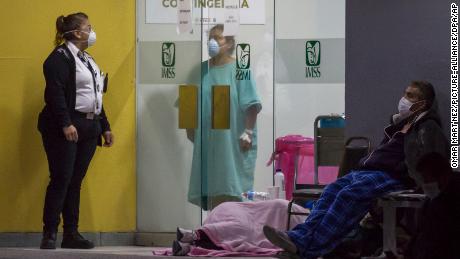 People wearing face masks wait outside an emergency room in Tijuana to be tested for coronavirus in April. 