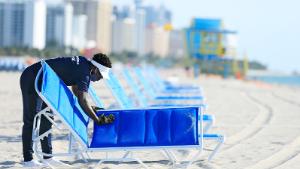 MIAMI BEACH, FLORIDA - JUNE 10: A man sets up rental beach lounge chairs on South Beach, June 10, 2020 in Miami Beach, Florida. Miami-Dade county and the City of Miami opened their beaches today as the area eases restrictions put in place to contain COVID-19. (Photo by Cliff Hawkins/Getty Images)
