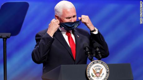 Vice President Mike Pence removes his mask to speak at the First Baptist Church Dallas during a rally on Sunday.