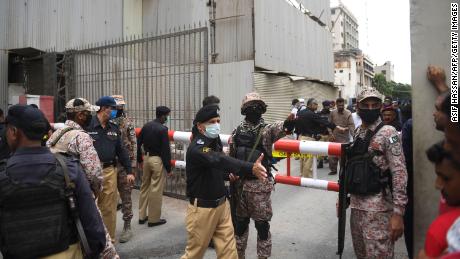 Personalul de securitate se adună la intrarea principală a clădirii Bursei Pakistanului din Karachi pe 29 iunie 2020.
