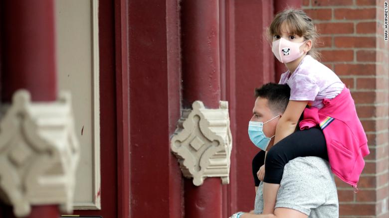 A man and a girl hear a band outside a music venue in Nashville, Tenn. The Nashville Health Department has a mask mandate to help battle the spread of the coronavirus.
