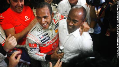 Hamilton celebrates with his father Anthony Hamilton (R) in his team garage following the Brazilian Grand Prix at the Interlagos Circuit on November 2, 2008 in Sao Paulo, Brazil.