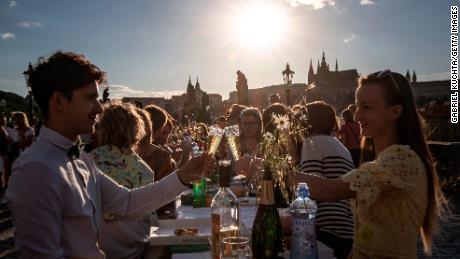 People dine at a communal table stretching across the Charles Bridge in Prague after coronavirus restrictions were eased on June 30, 2020.
