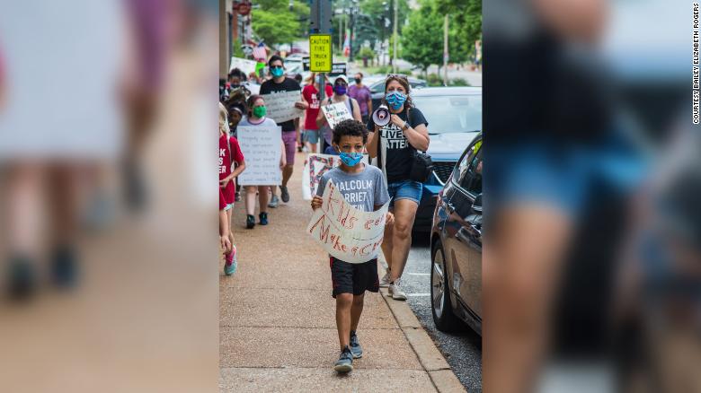 Nolan Davis leading Saturday's protest with his poster that reads "Kids can make a change." 