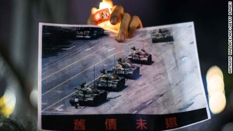 A man holds a poster of the famous &#39;Tank Man&#39; who stood in front of Chinese military tanks at Tiananmen Square in Beijing in 1989.