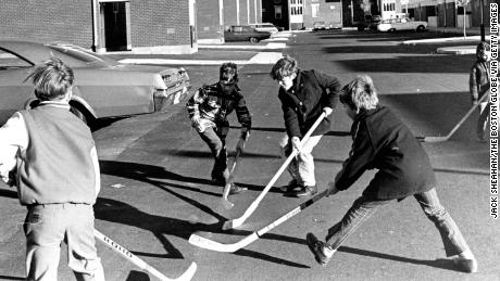 A group of children play street hockey outside of homes on Medford Street in the Charlestown neighborhood of Boston on Nov. 19, 1971.