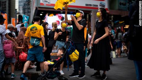 A family in Causeway Bay is seen with signs and yellow paraphernalia, the color of the pro-democracy movement.