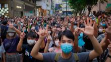 Protesters hold five fingers up in Hong Kong to signal their five demands against the new national security law on July 1, 2020. 